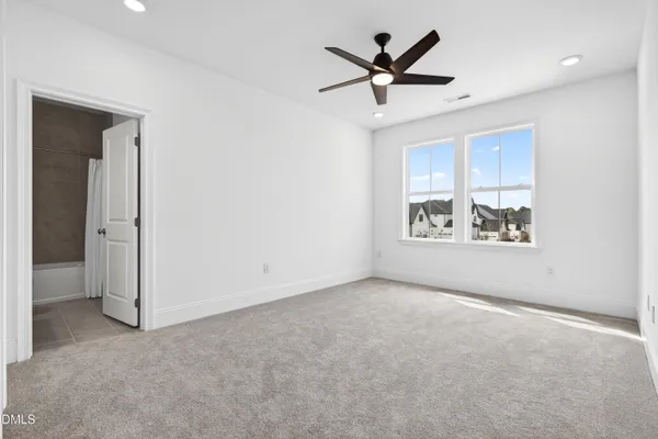 an empty room with closet and a ceiling fan