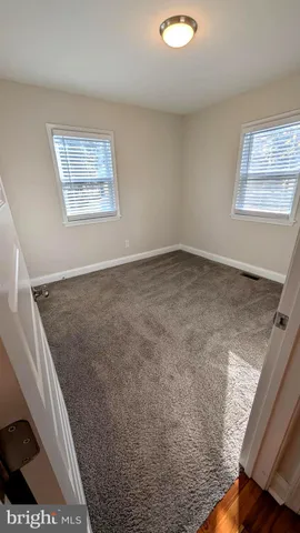 a view of a room with wooden floor and window