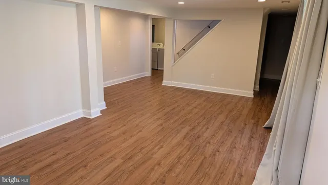 an empty room with wooden floor and entryway