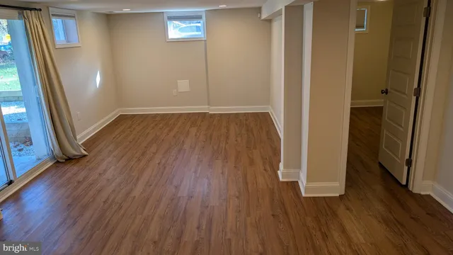 an empty room with wooden floor and entrance