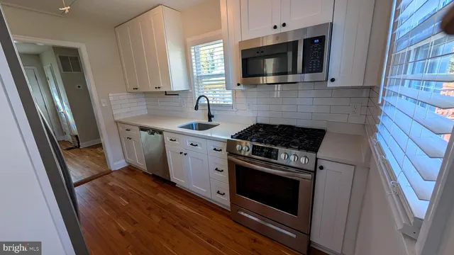 a kitchen with stainless steel appliances a stove microwave and sink