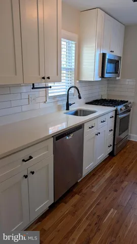 a kitchen with stainless steel appliances granite countertop a sink a stove and cabinets