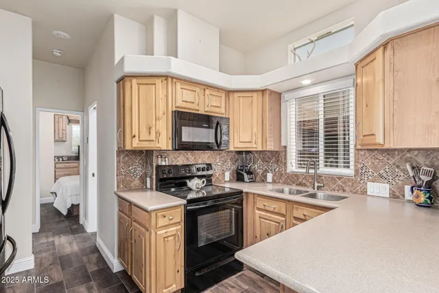 a living room with furniture a flat screen tv and kitchen view