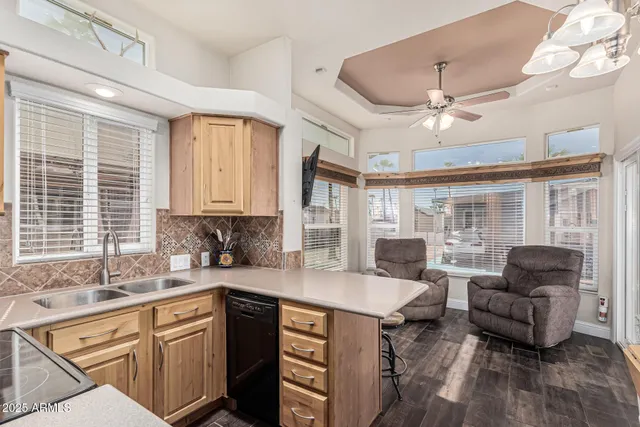 a kitchen with stainless steel appliances kitchen island granite countertop a dining table chairs sink and cabinets