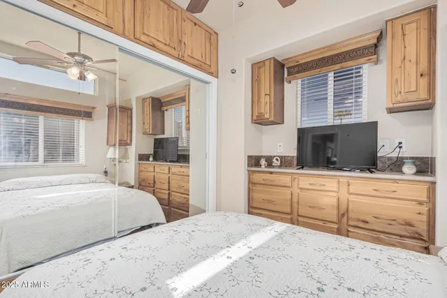 a bedroom with a bed a window and flat screen tv