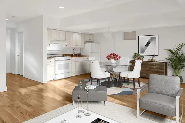 a view of kitchen cabinet and empty room with wooden floor