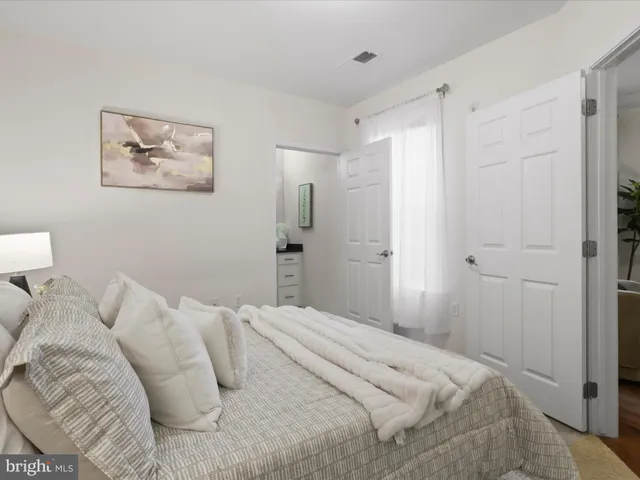 a bedroom with a bed and painting on the wall