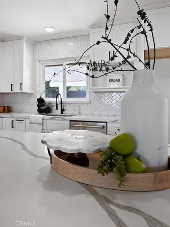 a room with kitchen island stainless steel appliances living room view