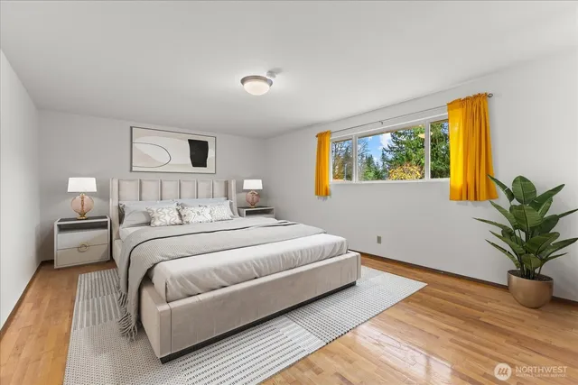 a bedroom with a large bed and a potted plant