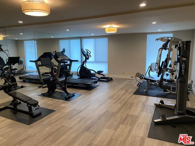 a room with gym equipment and kitchen view