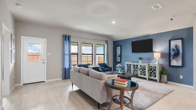 a living room with stainless steel appliances lots of furniture and kitchen view