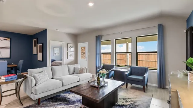 a living room with furniture a flat screen tv and kitchen view