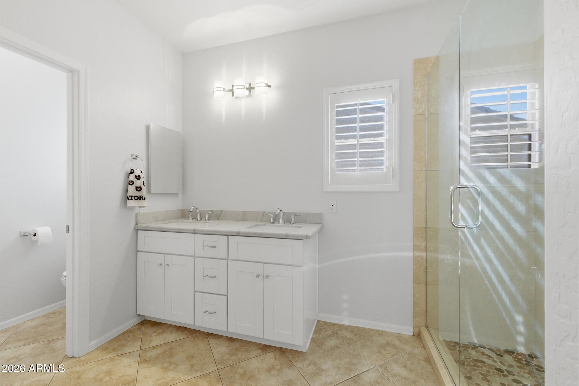 3425 East Mockingbird Drive Gilbert, AZ 85234 - Photo 38 of 52 a bathroom with a granite countertop sink a mirror and a shower