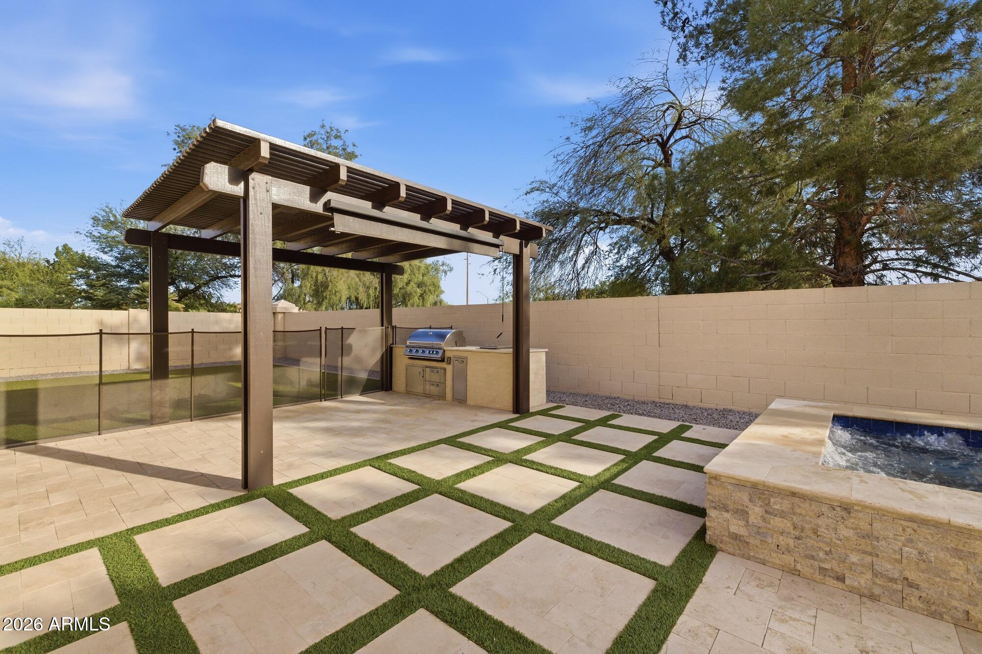 3425 East Mockingbird Drive Gilbert, AZ 85234 - Photo 49 of 52 a backyard of a house with table and chairs under an umbrella
