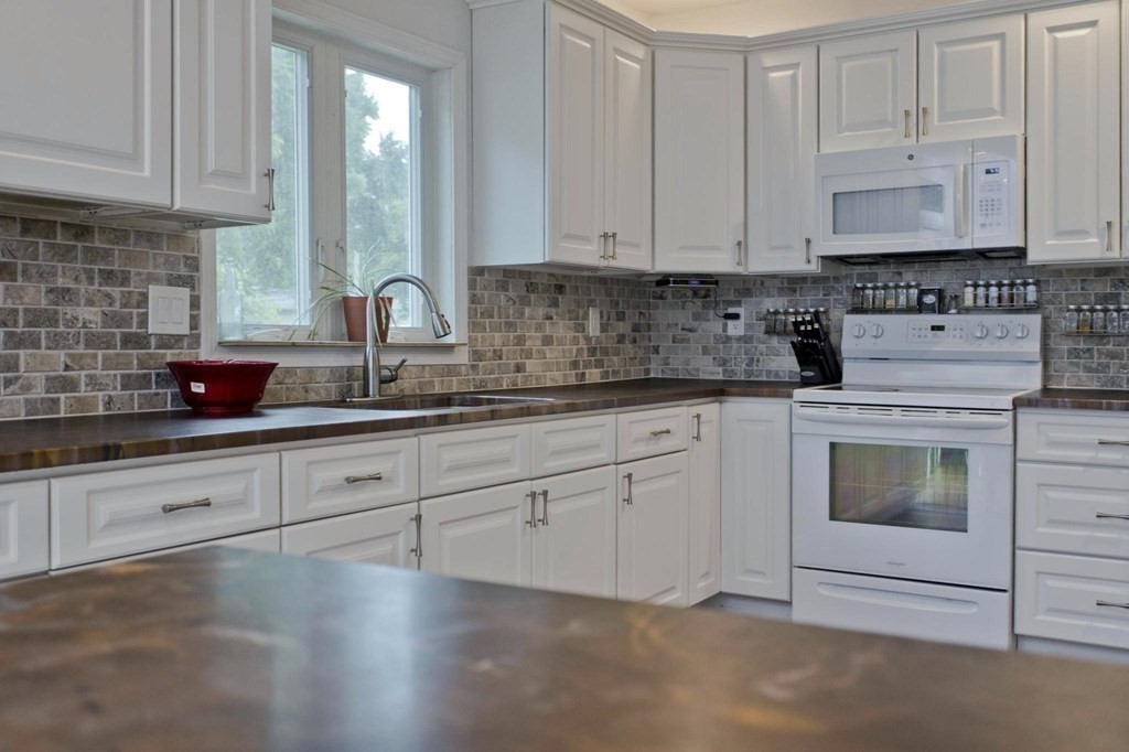 180 Granby Road Chicopee, MA 01013 - Photo 3 of 30 a kitchen with granite countertop white cabinets sink and stainless steel appliances