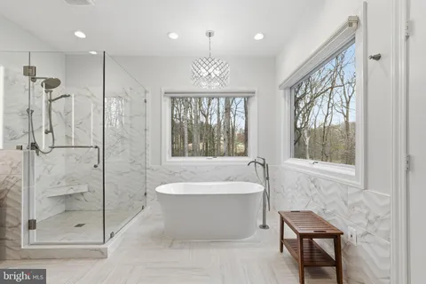 a bathroom with a sink a toilet a mirror a bathtub and shower