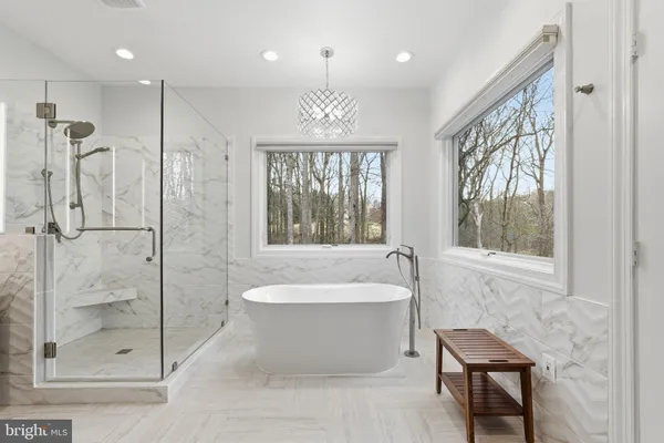 a bathroom with a sink a toilet a mirror a bathtub and shower