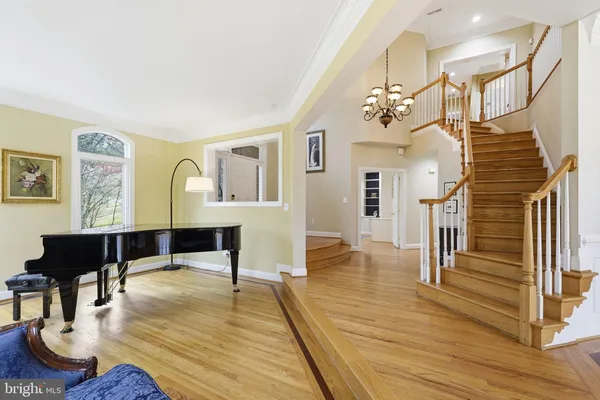 a view of a livingroom with furniture a chandelier and wooden floor