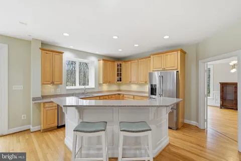 a kitchen with kitchen island a large counter top space and stainless steel appliances