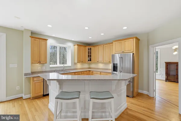a kitchen with kitchen island a large counter top space and stainless steel appliances