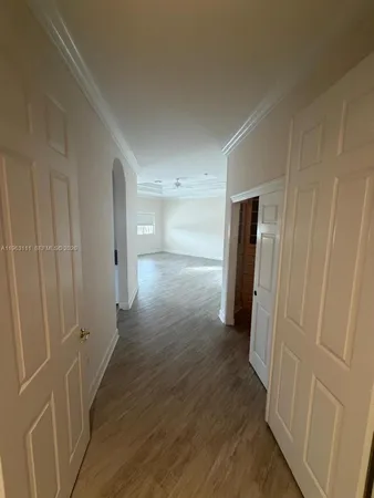 a view of a hallway with wooden floor