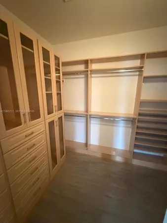 a view of walk in closet with empty racks