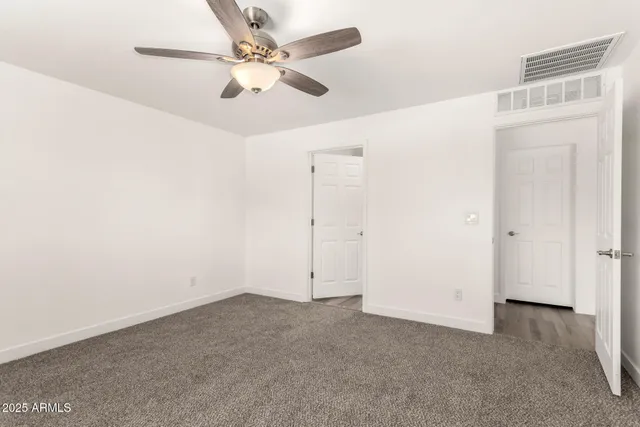 an empty room with fan and ceiling fan
