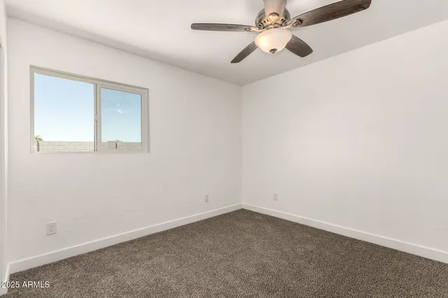 an empty room with chandelier fan