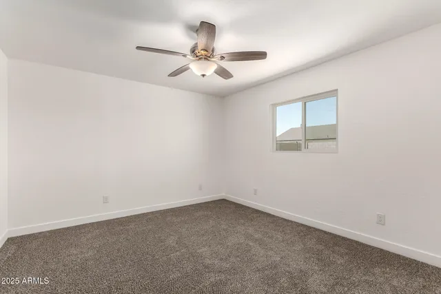 an empty room with a ceiling fan and a fan