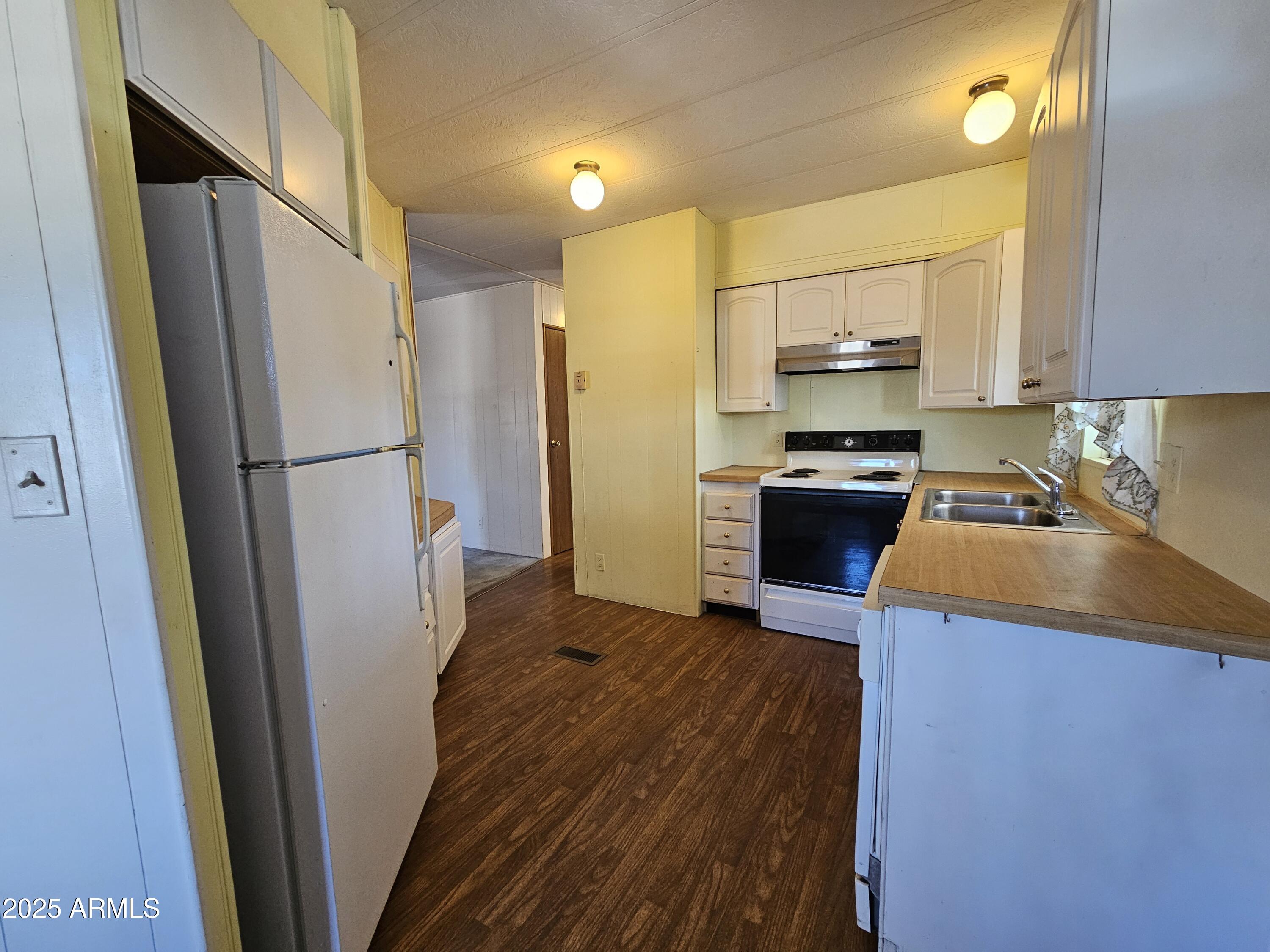 200 East Ivanhoe Street, Unit 60 Chandler, AZ 85225 - Photo 2 of 10 a kitchen with a refrigerator a stove top oven a sink and dishwasher