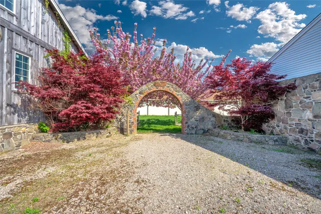 a view of a house with large tree and wooden fence