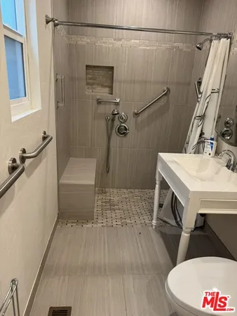 a bathroom with a sink a toilet and shower