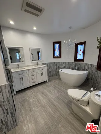 a bathroom with a double vanity sink a large mirror and shower