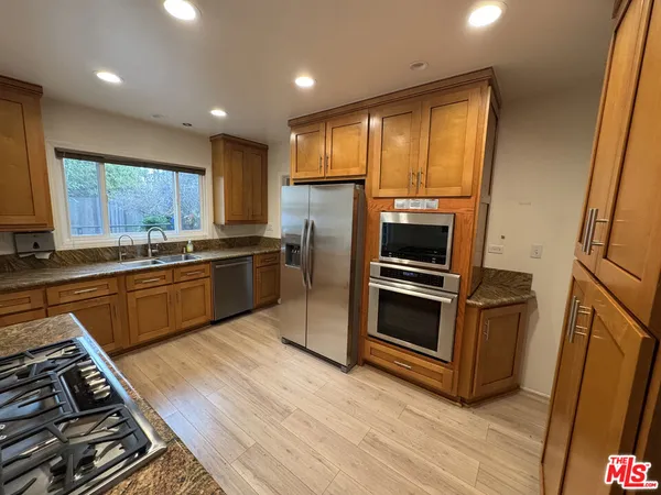 a kitchen with stainless steel appliances a stove a sink and a refrigerator