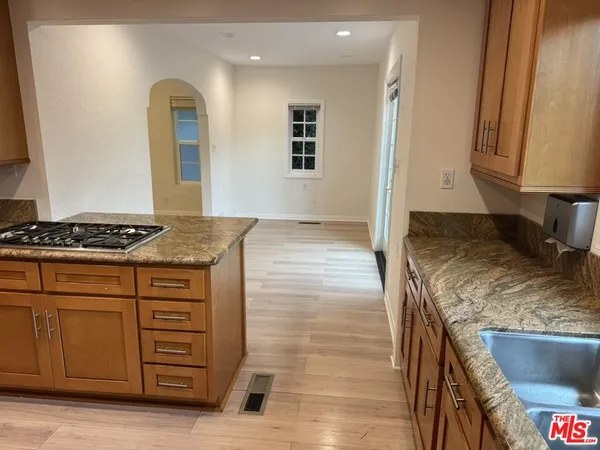 a kitchen with granite countertop a sink stove and cabinets