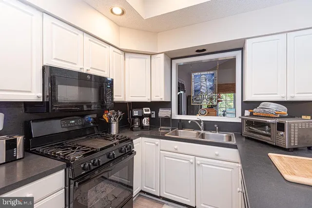 a kitchen with stainless steel appliances a stove a sink and a microwave