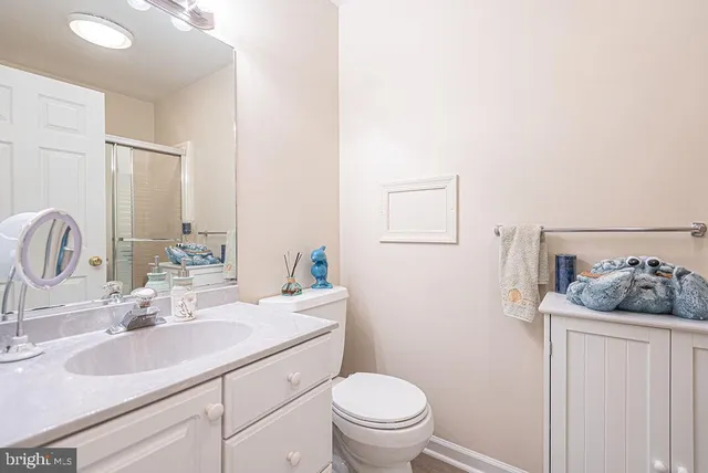 a bathroom with a granite countertop sink a toilet and a mirror