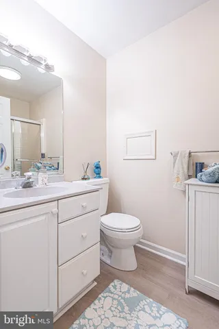 a bathroom with a toilet a sink a mirror and vanity