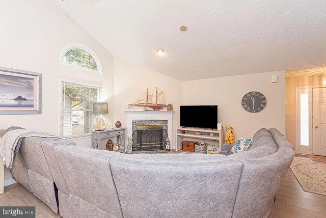 a living room with furniture a fireplace and a flat screen tv