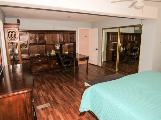 a bedroom with wooden floor and furniture