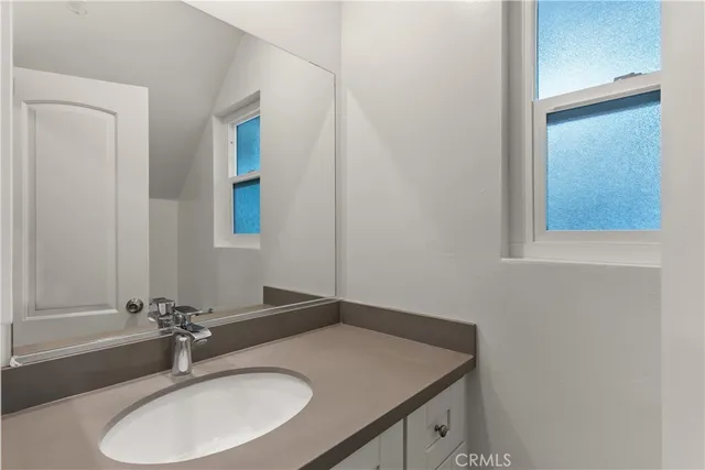 a bathroom with a granite countertop sink and a mirror
