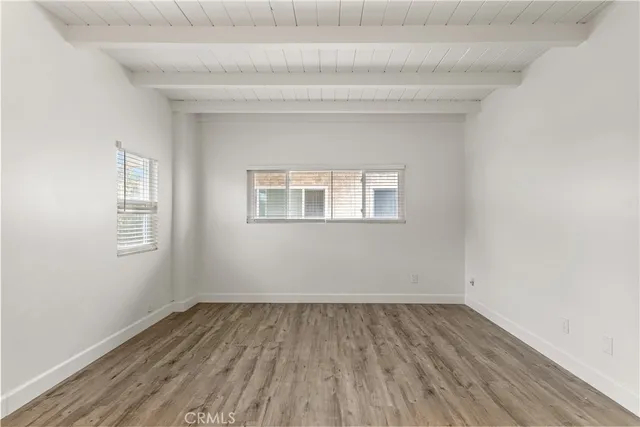 a view of a room that has wooden floor and window
