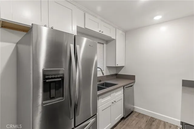 a kitchen with metallic refrigerator and cabinets