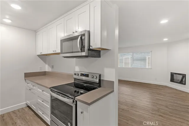 a kitchen with granite countertop a stove and a microwave