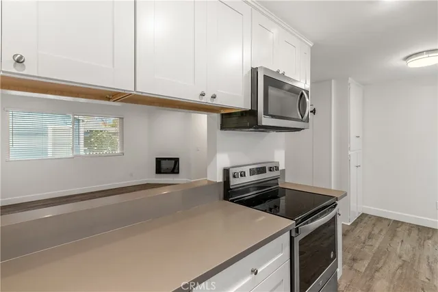 a kitchen with granite countertop a stove and a microwave