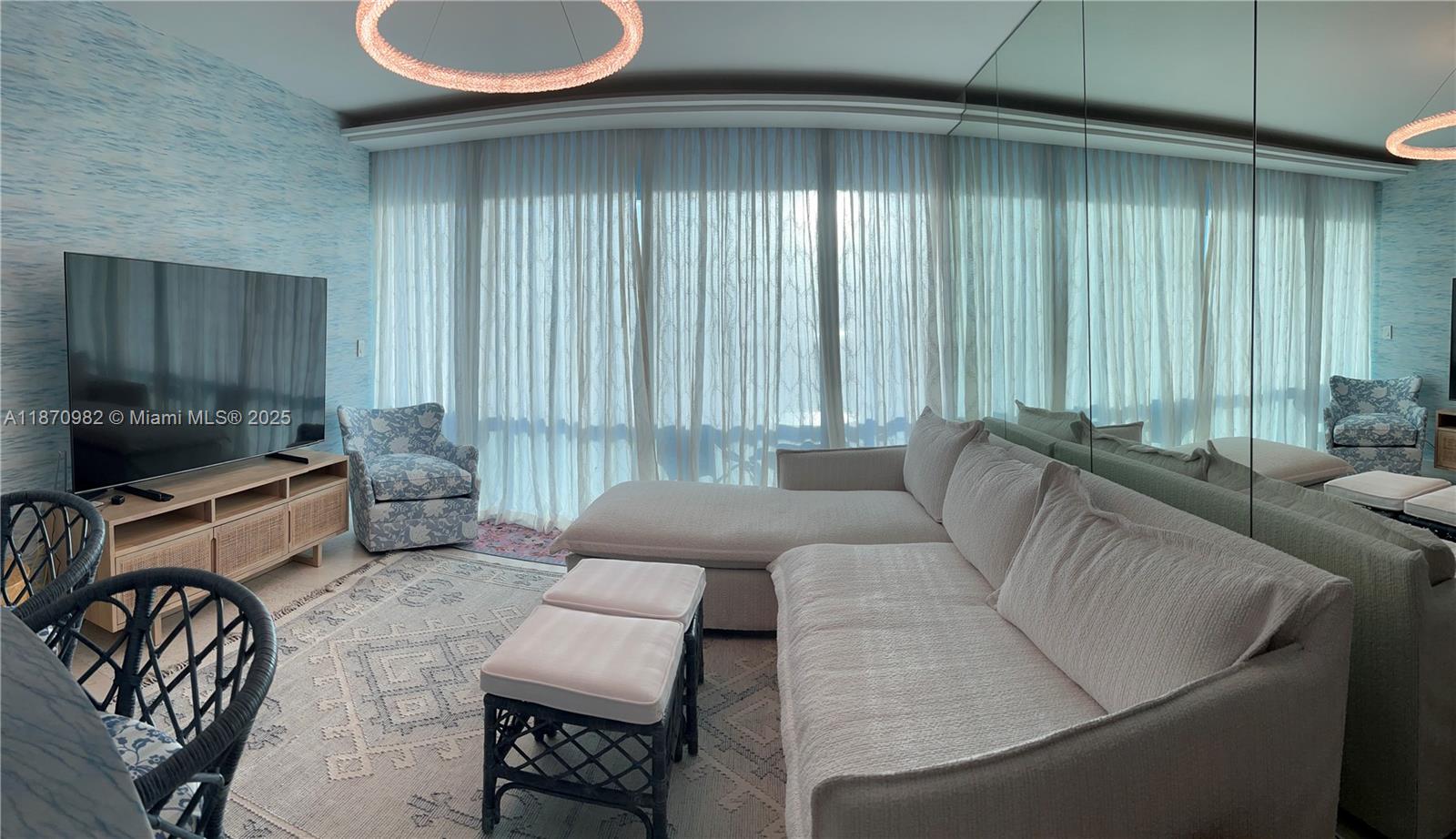 6799 Collins Avenue, Unit 1601 Miami Beach, FL 33141 - Photo 2 of 27 a living room with furniture and a flat screen tv