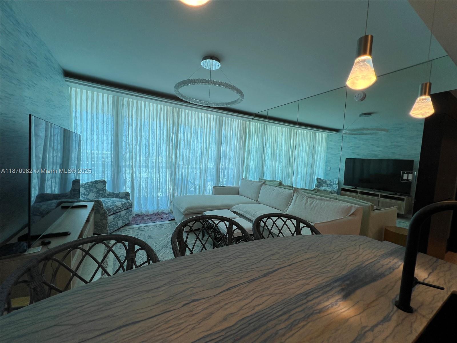 6799 Collins Avenue, Unit 1601 Miami Beach, FL 33141 - Photo 3 of 27 a view of a dining room with furniture window and wooden floor