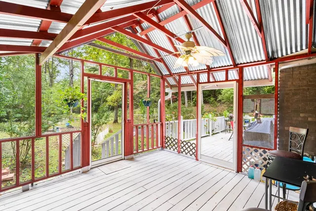 a house with wooden deck and furniture in front of it