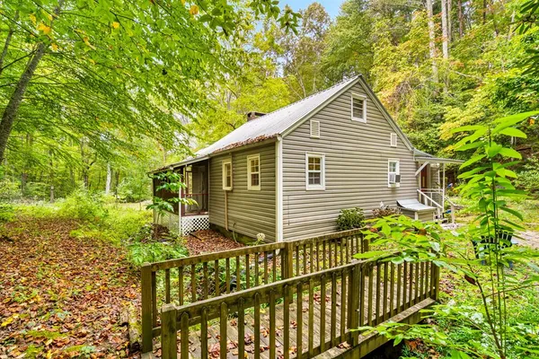 a yellow house with flower garden in front of it