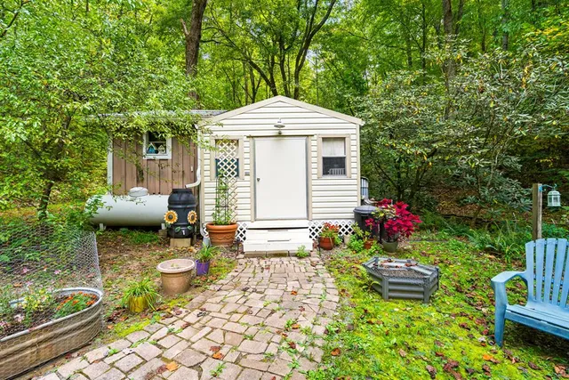 a view of a house with a yard and large tree